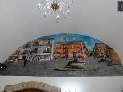 A questo punto Guaragno ci accompagna alla scoperta di qualche suo altro �attacco d�arte�. Iniziamo da corso Vittorio Emanuele II. Qui, all�interno della pasticceria Mercantile, ha realizzato una mezzaluna con una panoramica sull�omonima piazza, dove un tempo sorgeva la vecchia sede dell�esercizio